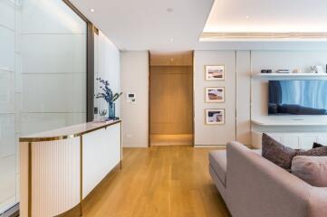 Modern living room with wooden flooring, sofa, and TV