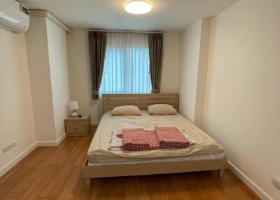 Cozy bedroom with wooden flooring and ample natural light