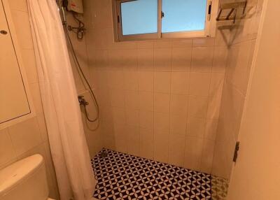 Bathroom with tiled shower area and white curtain