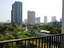 Balcony with a view of high-rise buildings and greenery