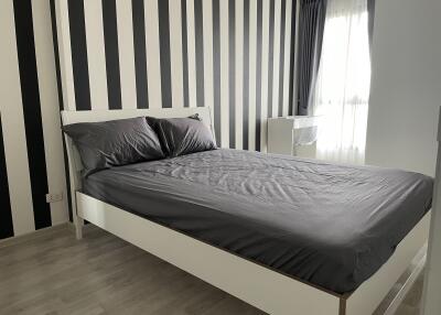 Modern bedroom with black and white striped accent wall