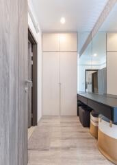 Modern entryway with wooden flooring, built-in closets, and full-length mirror