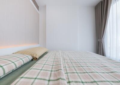 Modern bedroom with checkered bedding and large window with curtains