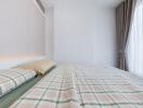 Modern bedroom with checkered bedding and large window with curtains