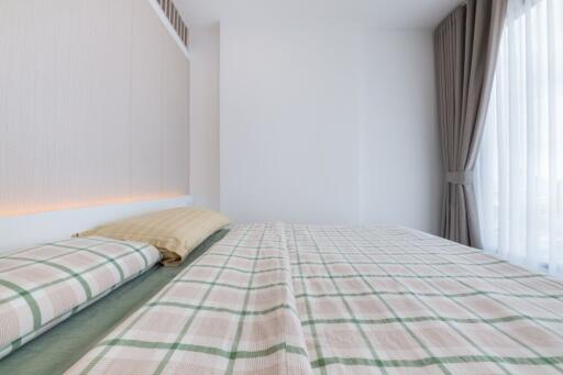 Modern bedroom with checkered bedding and large window with curtains