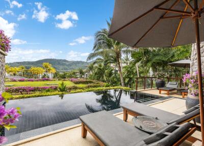 Luxurious outdoor pool area with sun loungers and tropical plants