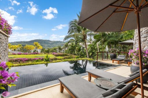 Luxurious outdoor pool area with sun loungers and tropical plants