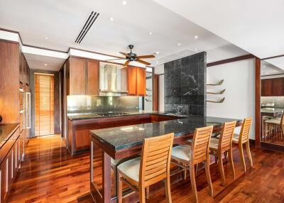 Spacious modern kitchen with wooden cabinets, large island, and dining area