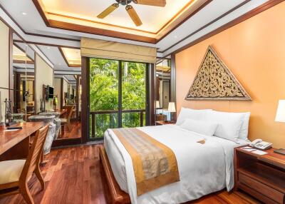 Modern bedroom with wooden floors, large windows, and decorative wall art