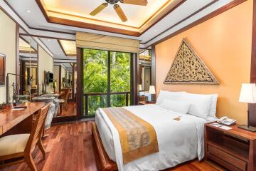 Modern bedroom with wooden floors, large windows, and decorative wall art