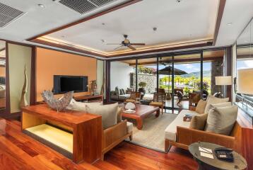 Modern living room with wooden furniture and large glass doors opening to a patio