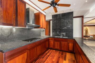 Modern kitchen with wooden cabinetry and dark granite countertops