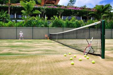 Tennis court with net, tennis balls, and a racket