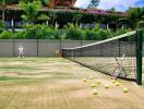 Tennis court with net, tennis balls, and a racket