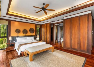 Spacious bedroom with wooden floors, large bed, and ceiling fan