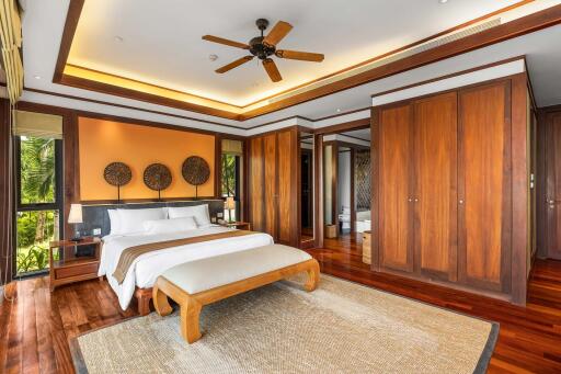 Spacious bedroom with wooden floors, large bed, and ceiling fan