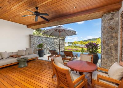 Spacious outdoor patio with seating area, wooden flooring, and garden view.