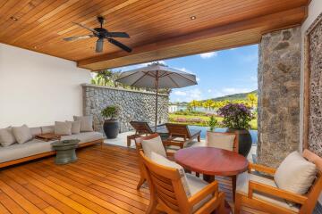 Spacious outdoor patio with seating area, wooden flooring, and garden view.