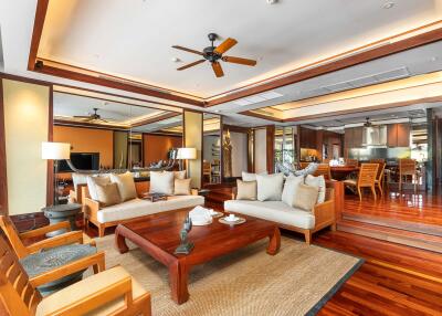 Spacious modern living room with wooden flooring, ceiling fans, and comfortable seating