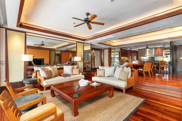 Spacious modern living room with wooden flooring, ceiling fans, and comfortable seating