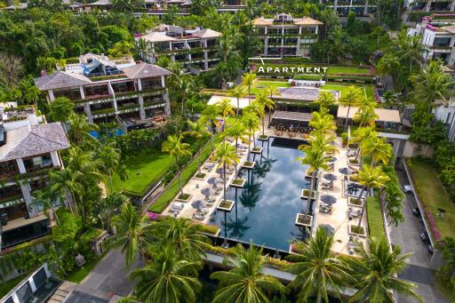 Aerial view of a luxury residential complex with swimming pool and surrounding greenery