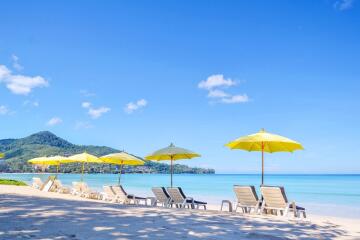 Beautiful beach with lounge chairs and yellow umbrellas