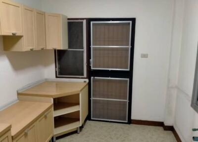 Simple kitchen with wooden cabinets and a door