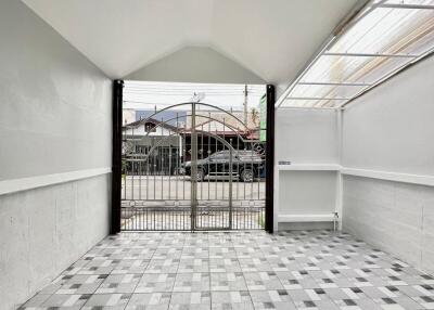 Covered garage with tiled floor and gated entrance