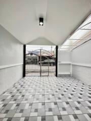 Covered garage with tiled floor and gated entrance