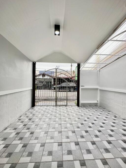 Covered garage with tiled floor and gated entrance