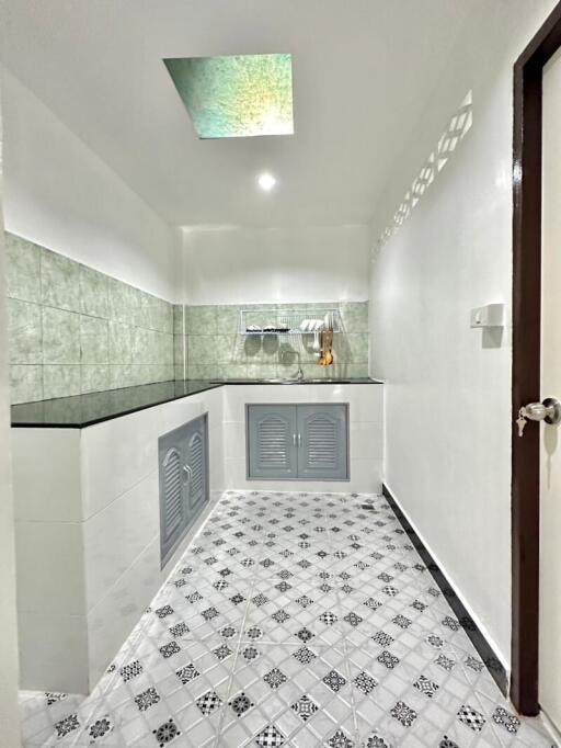 Modern kitchen with tiled backsplash and skylight