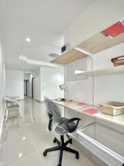 Modern home office with desk, chair, and shelves