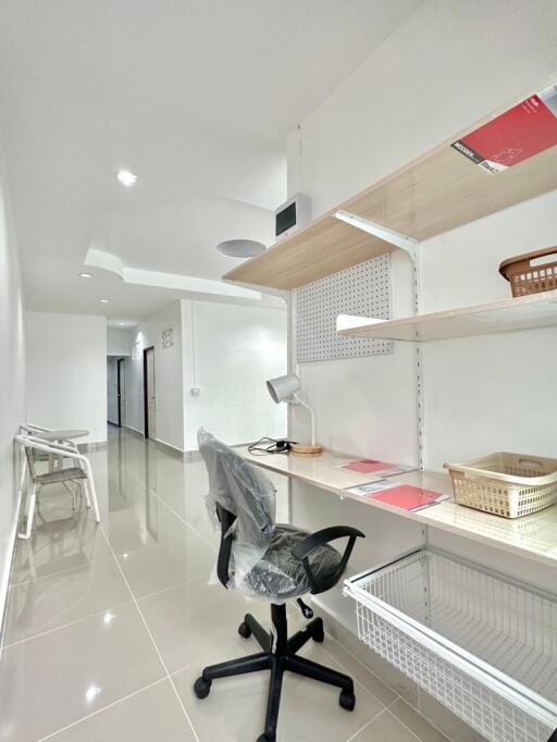 Modern home office with desk, chair, and shelves