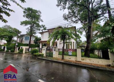 Exterior view of a property surrounded by trees on a rainy day