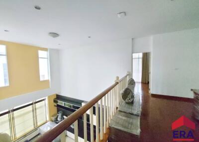 Upper floor view of a spacious living area with balcony railing