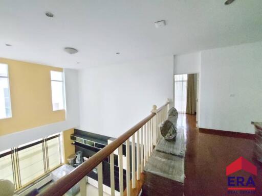 Upper floor view of a spacious living area with balcony railing