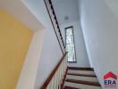 Indoor staircase with wooden handrail and vertical window