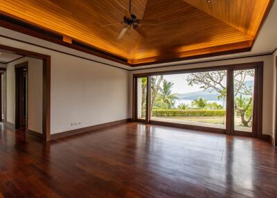 spacious living room with wooden ceiling and large windows facing a scenic view