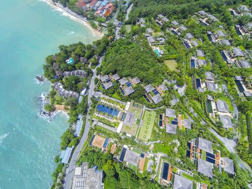 Aerial view of coastal resort with villas and greenery