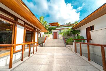 Exterior view of a modern house with wooden accents and a staircase leading to the main entrance