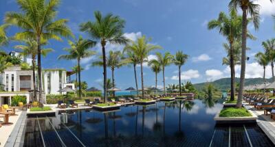 Luxury infinity pool surrounded by palm trees and lounge chairs with mountain view