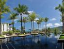 Luxury infinity pool surrounded by palm trees and lounge chairs with mountain view