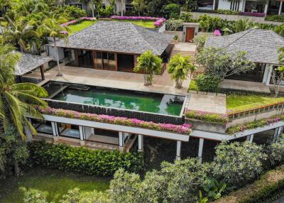 Aerial view of a luxurious villa with a private swimming pool and lush greenery