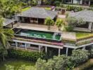 Aerial view of a luxurious villa with a private swimming pool and lush greenery