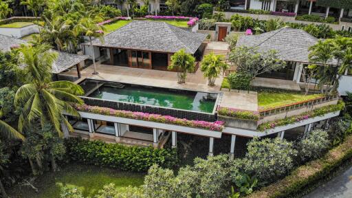 Aerial view of a luxurious villa with a private swimming pool and lush greenery