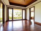 Spacious living room with wooden ceiling and floor, large windows, and outdoor view