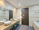 Modern bathroom with double sinks, bathtub, and large mirror