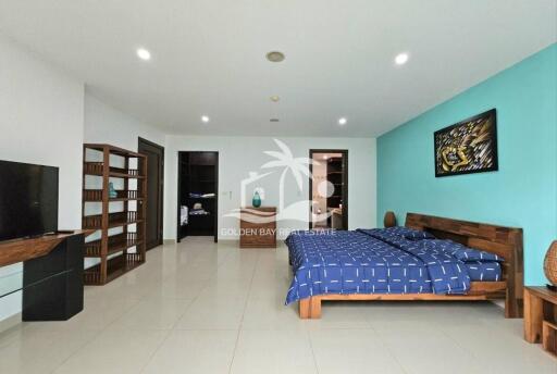 Spacious bedroom with wooden furniture and blue-themed decor