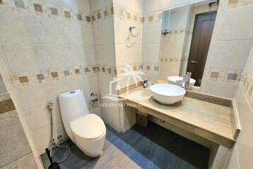 Modern bathroom with a toilet, sink, and vanity mirror