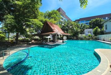 Outdoor swimming pool with a traditional pavilion and surrounding greenery